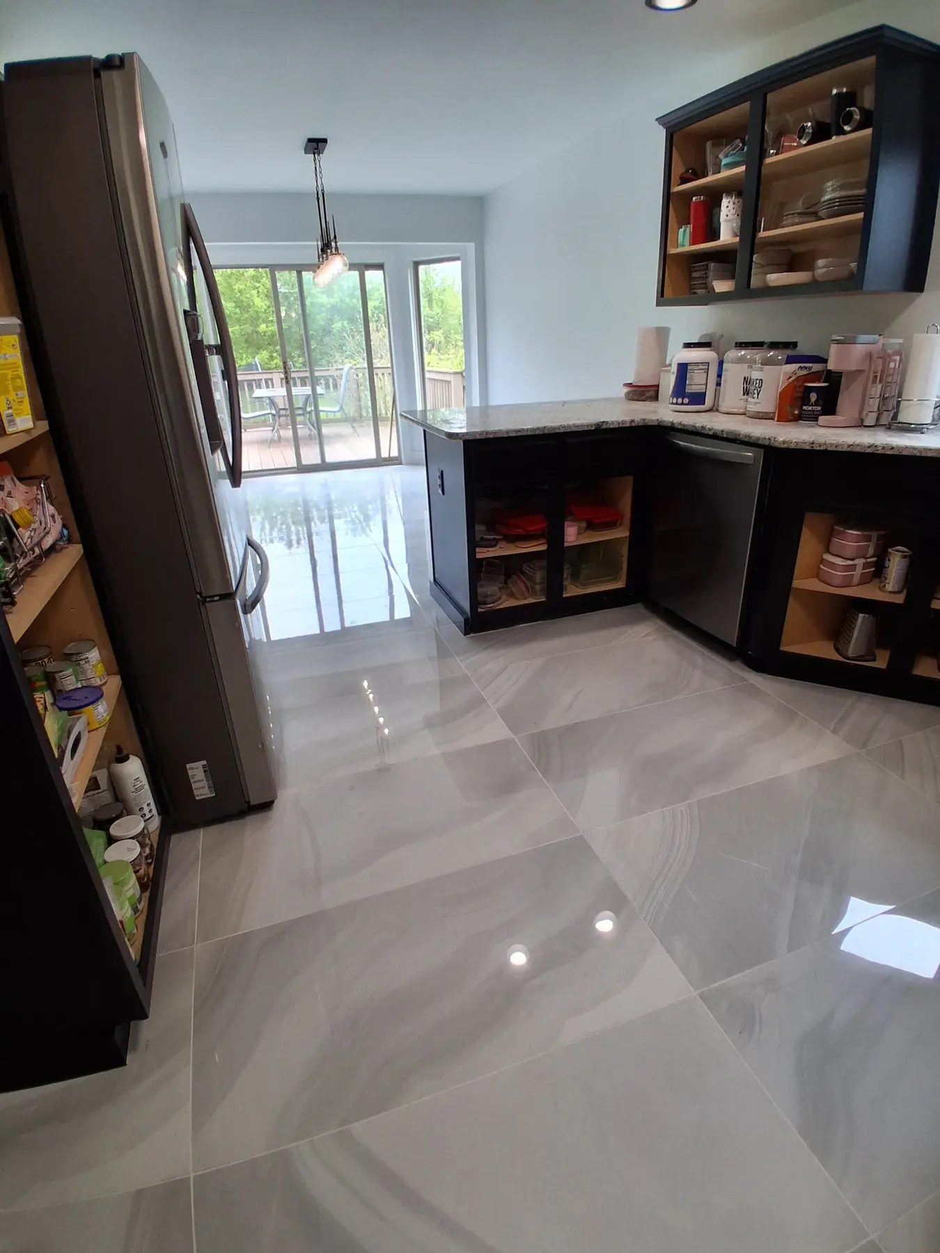Kitchen with polished porcelain floor reflecting the sliding door to the deck